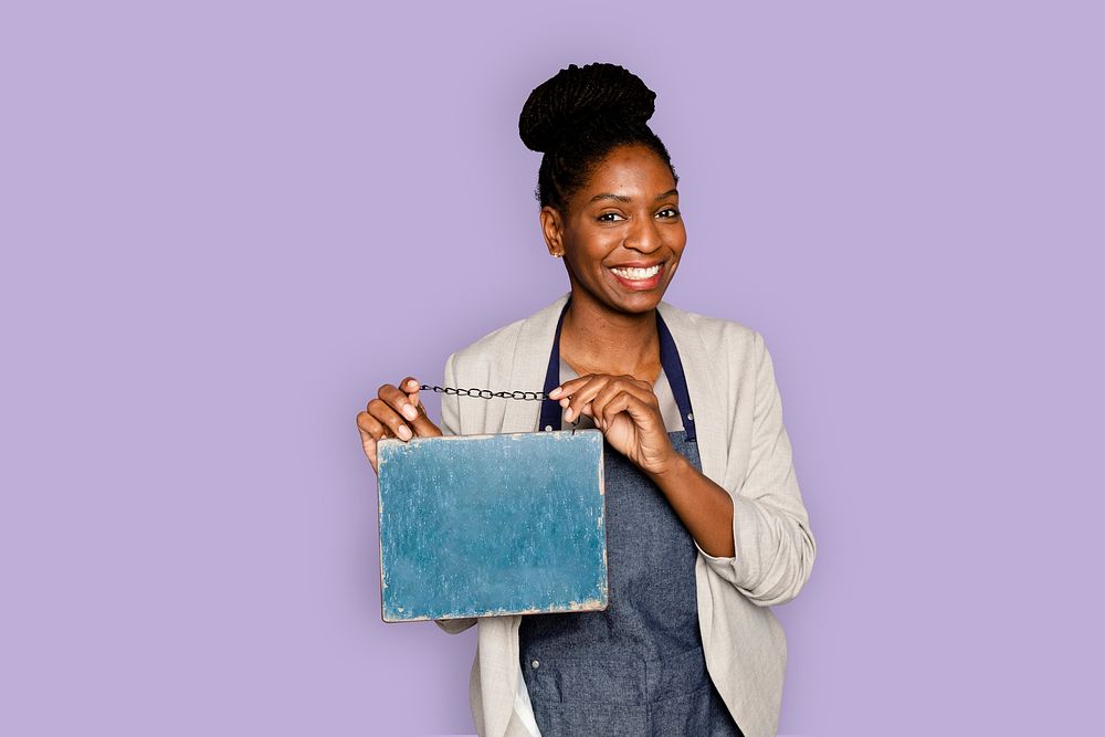 Hanging chalkboard sign for cafe held by a woman small business owner