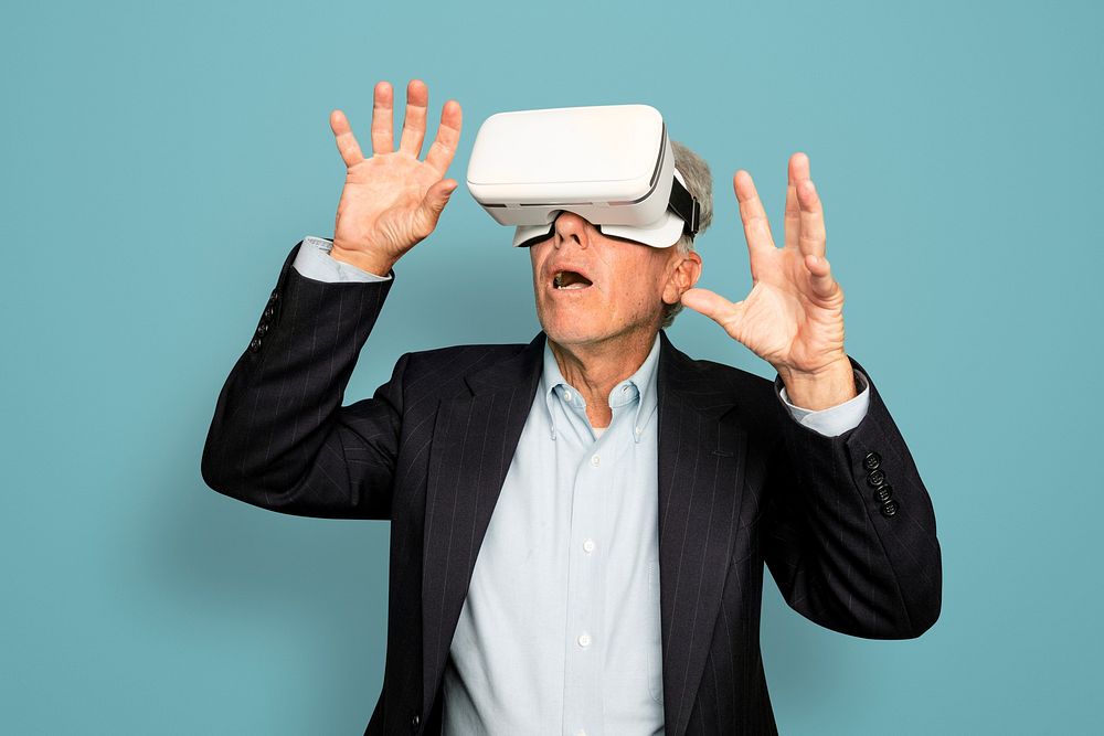 Senior man having fun with VR headset digital device