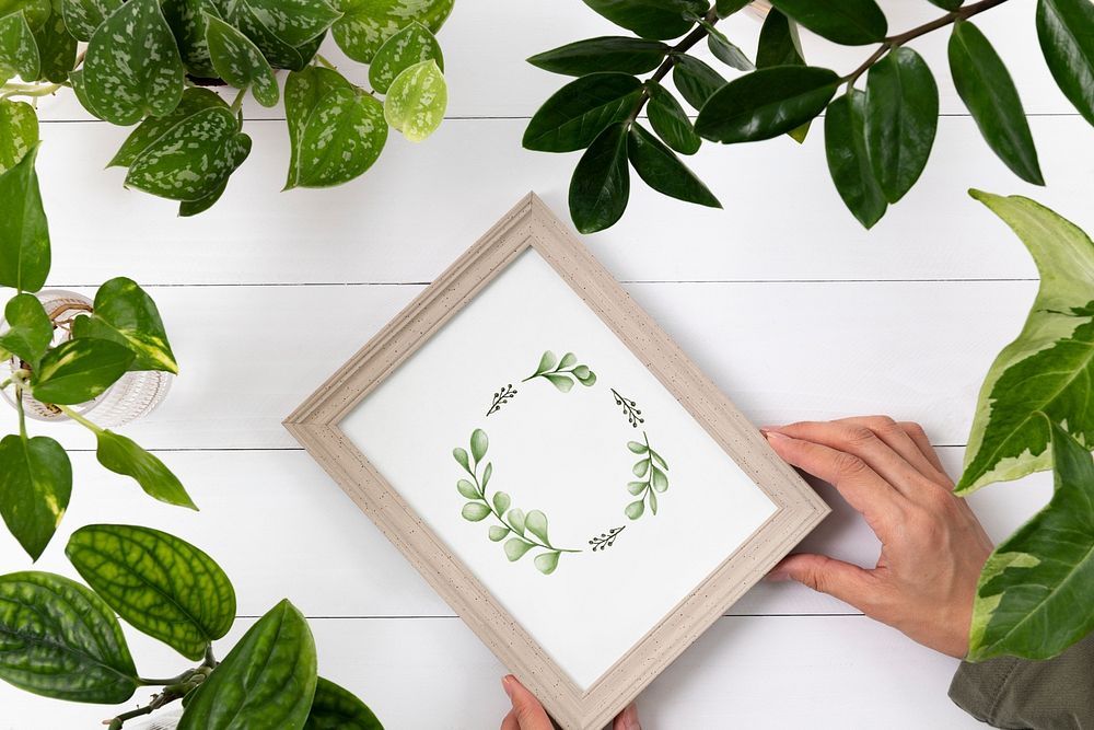 Picture frame mockup psd with leaves around flat lay
