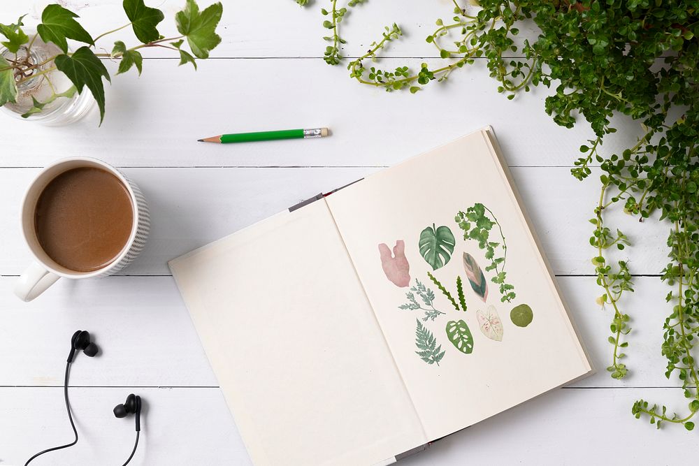 Book mockup psd on wooden table with potted plants flat lay