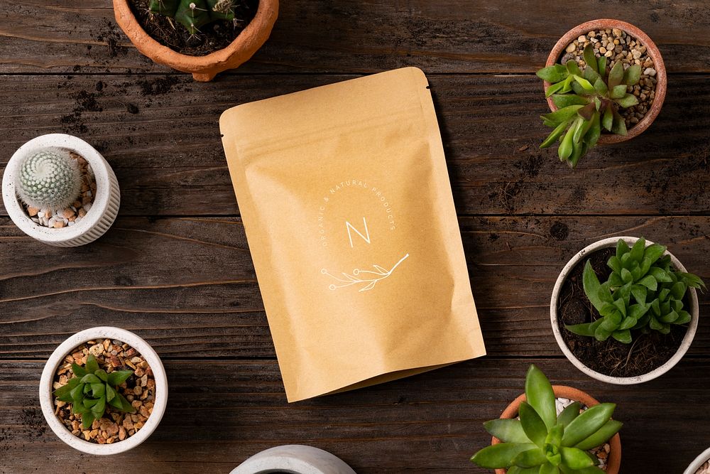 Pouch bag mockup psd on wooden table with plants flat lay