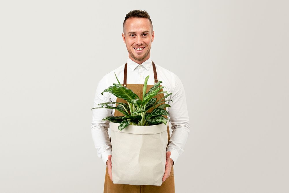 Plant shop owner mockup psd holding potted dumb cane