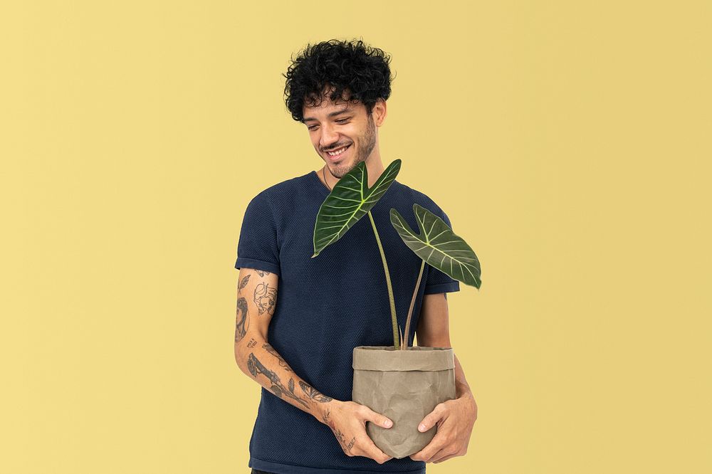 Happy plant parent mockup psd  holding potted alocasia longiloba