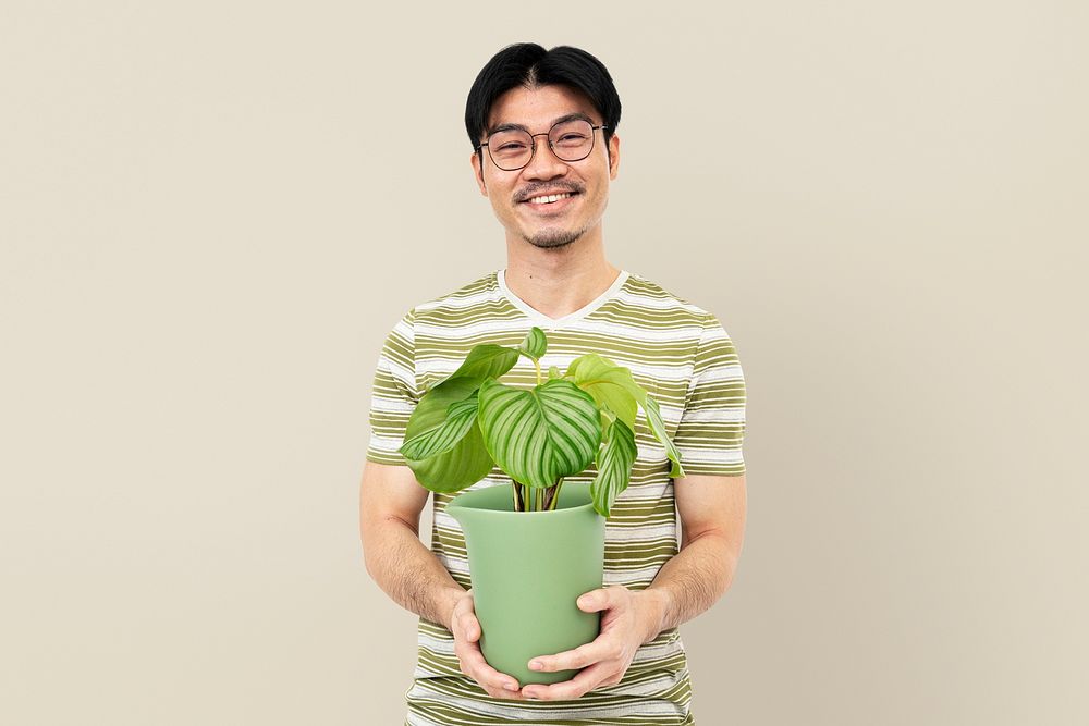 Asian plant lover mockup psd holding potted Calathea Orbifolia