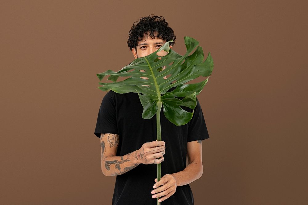 Plant lover mockup psd holding monstera leaf