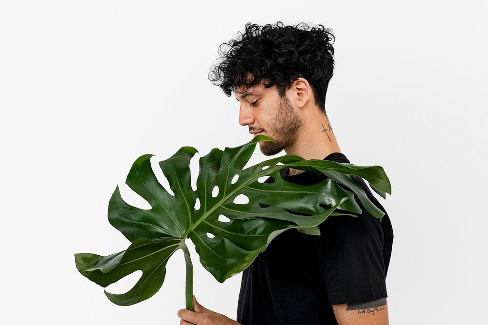 Plant lover mockup psd holding monstera leaf