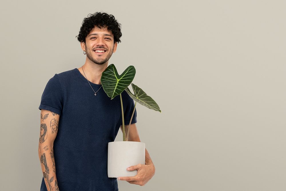 Happy plant parent mockup psd  holding potted alocasia longiloba