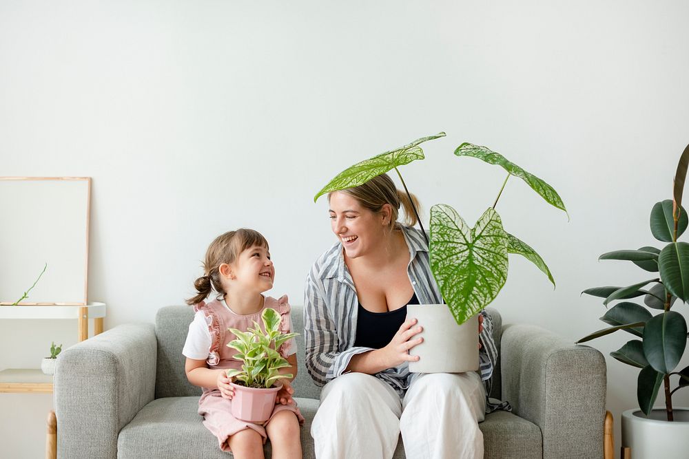 Happy daughter and mom holding potted plants