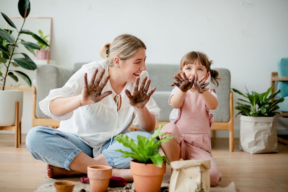 Playful kid potting plant at home as a hobby