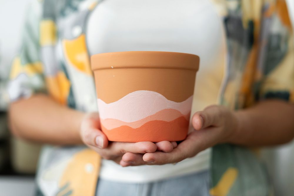 Woman holding DIY painted pot painting