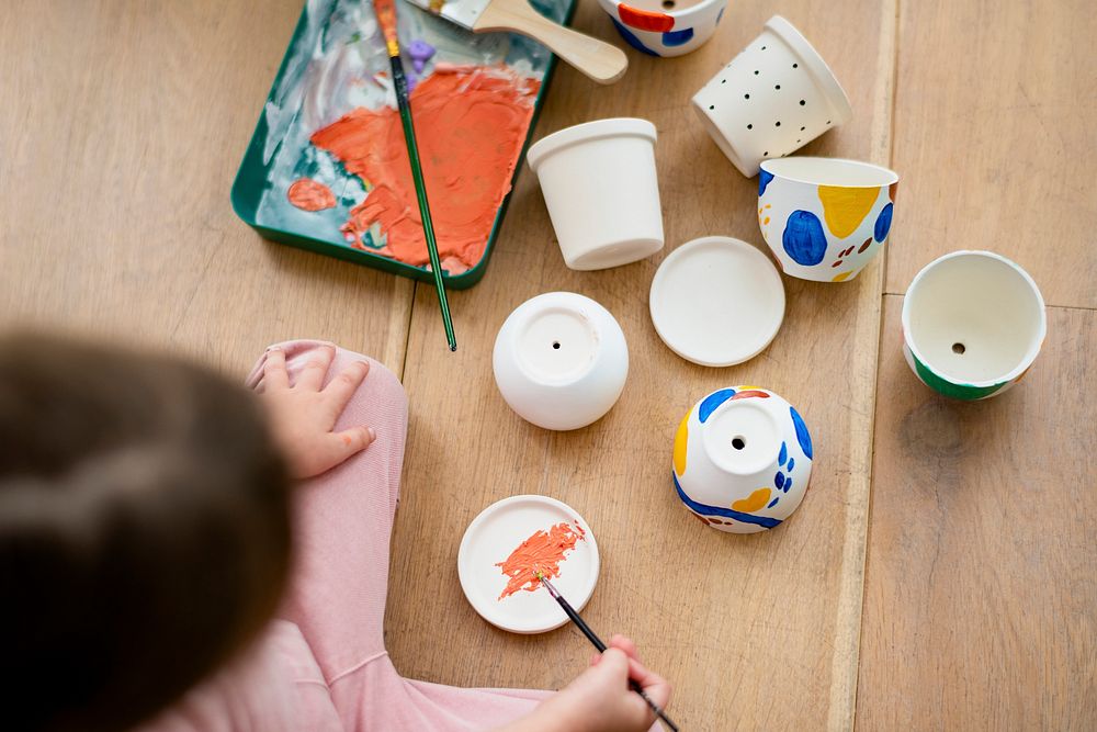 Little girl pot painting at home