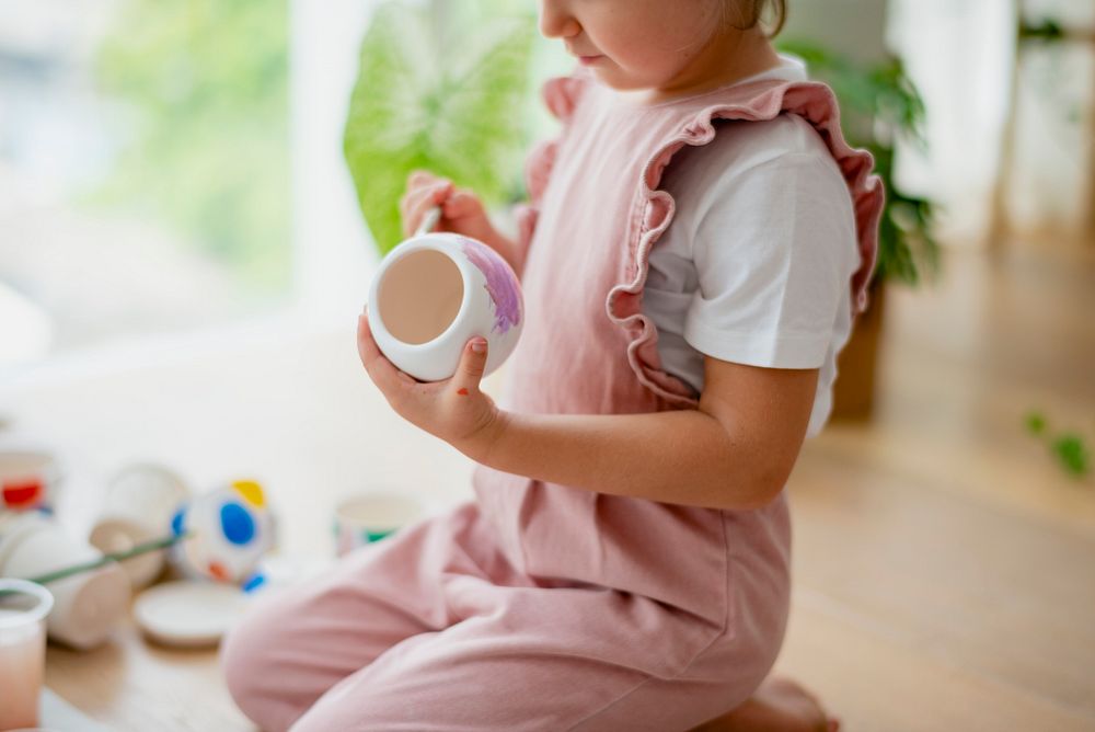 Little girl pot painting at home