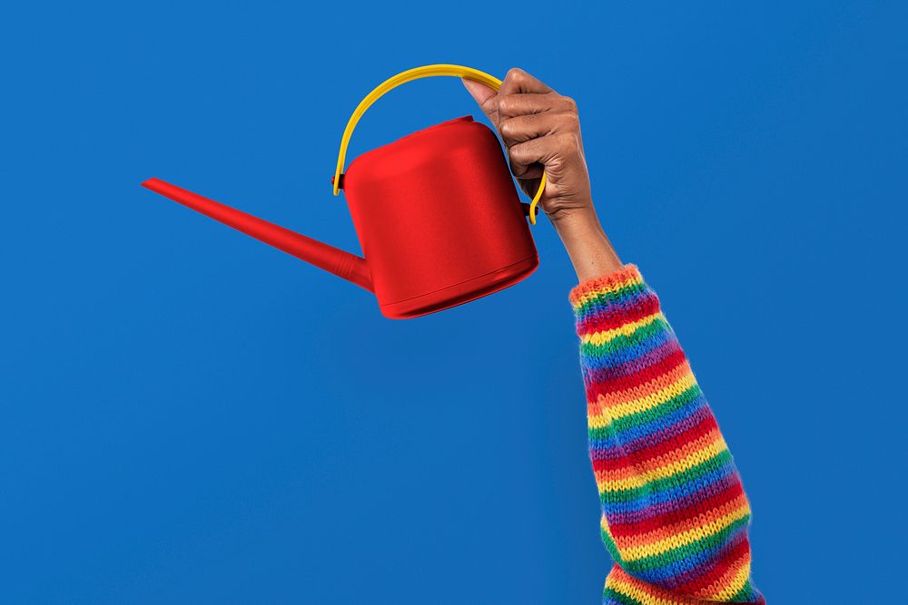 Hand mockup psd holding red watering can gardening tool