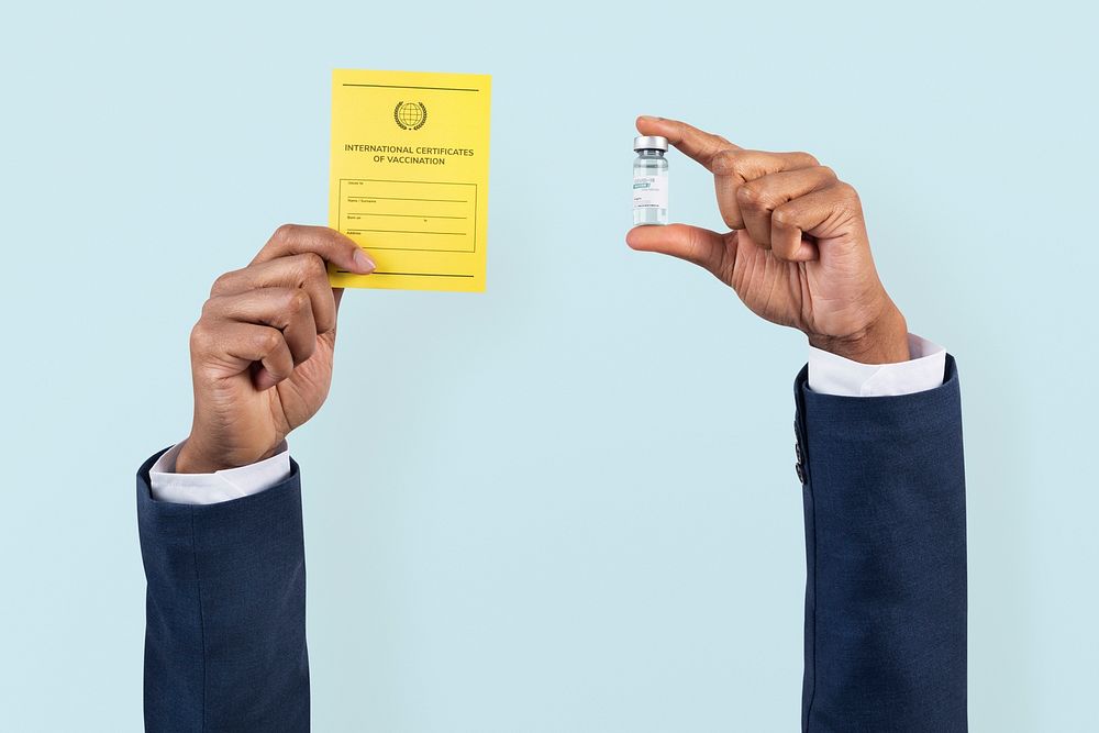 Covid-19 vaccine certificate mockup psd held by a businessman&rsquo;s hand