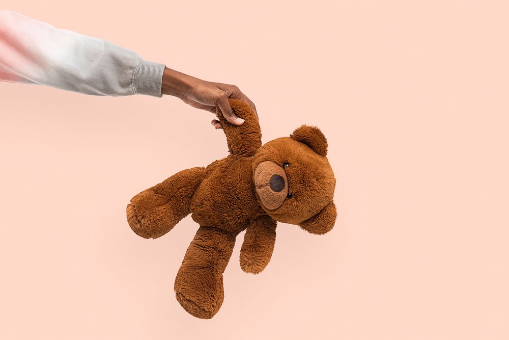 Teddy bear mockup psd held by a hand for charity campaign