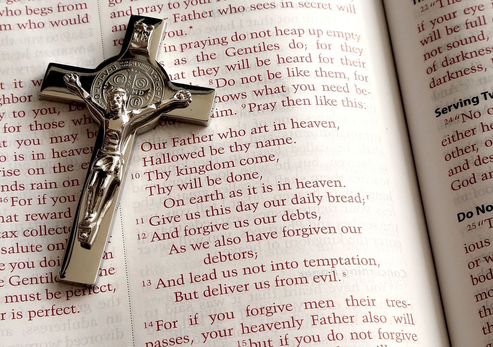 A crucifix on an open Bible showing the Lord's prayer (Matthew 6:9–13). Original public domain image from Wikimedia Commons
