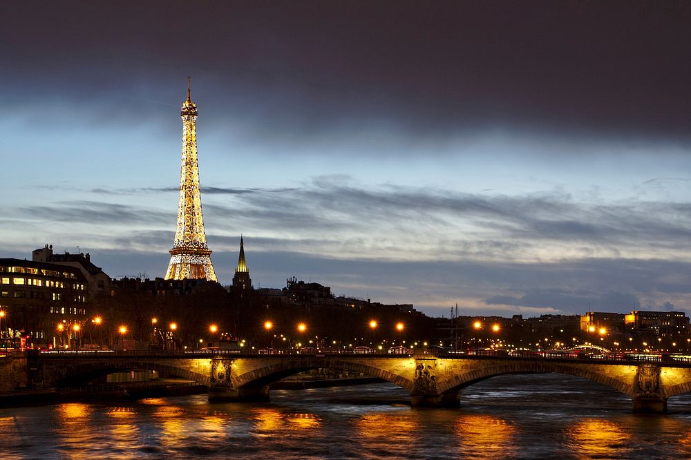 Eiffel Tower illuminated at nightfall in the heart of a city of light. Original public domain image from Wikimedia Commons
