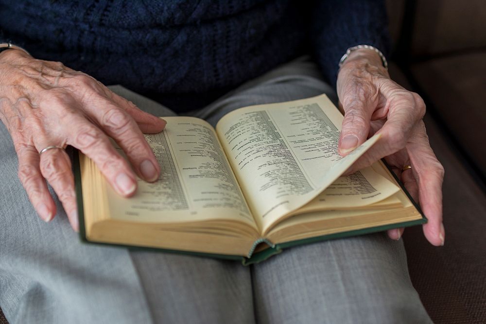 An elderly woman reading a book. Original public domain image from Wikimedia Commons
