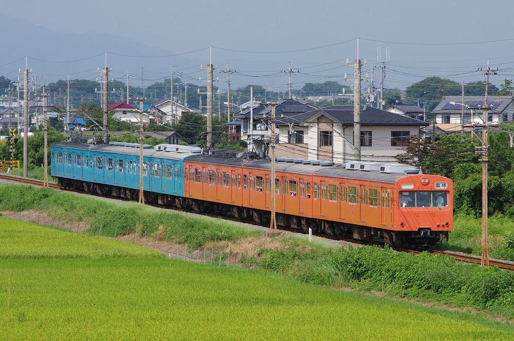 Two Chichibu Railway 1000 series 3-car EMU sets (numbers 1003 in red livery and 1001 in blue livery) running together on a…