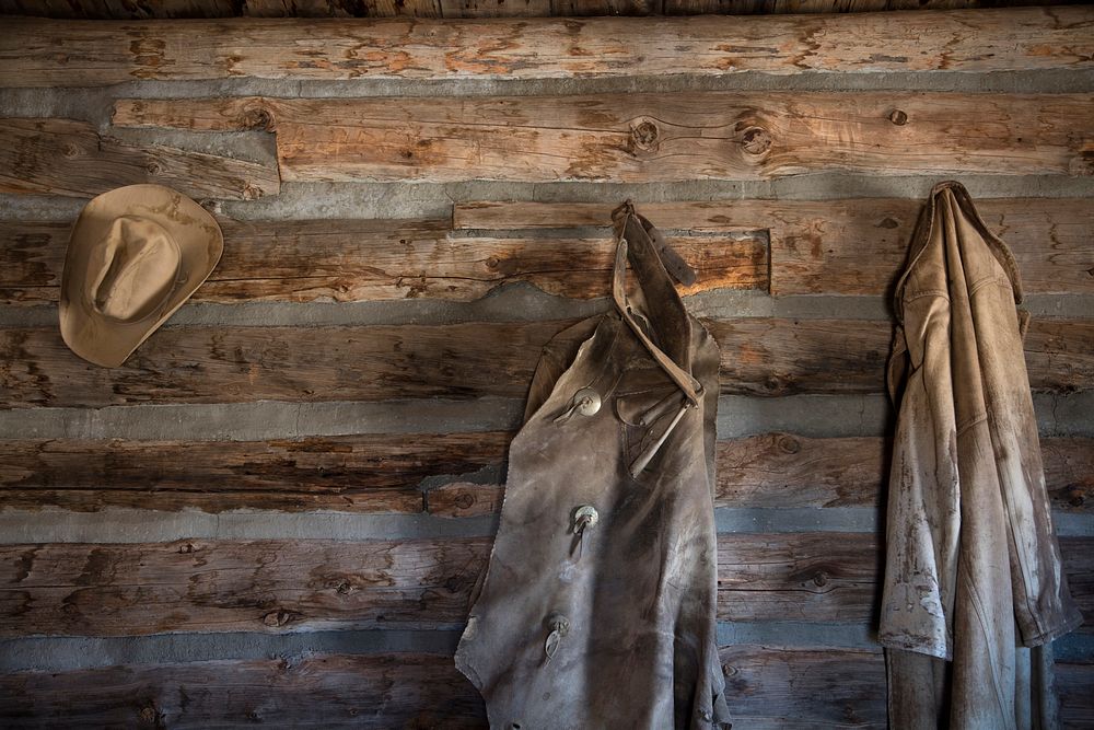 Coats and a cowboy hat at the "Hole-in-the-Wall" Cabin at Old Trail Town, a historic museum complex in Cody, Wyoming.