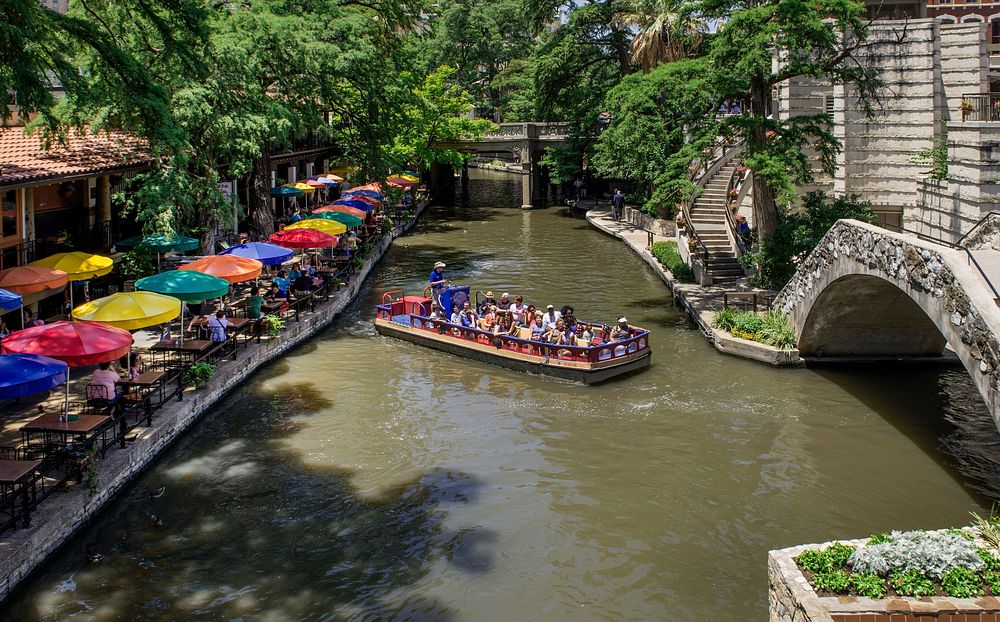 A barge loaded with visitors turns toward a tunnel on the portion of the San Antonio River that winds through San Antonio's…