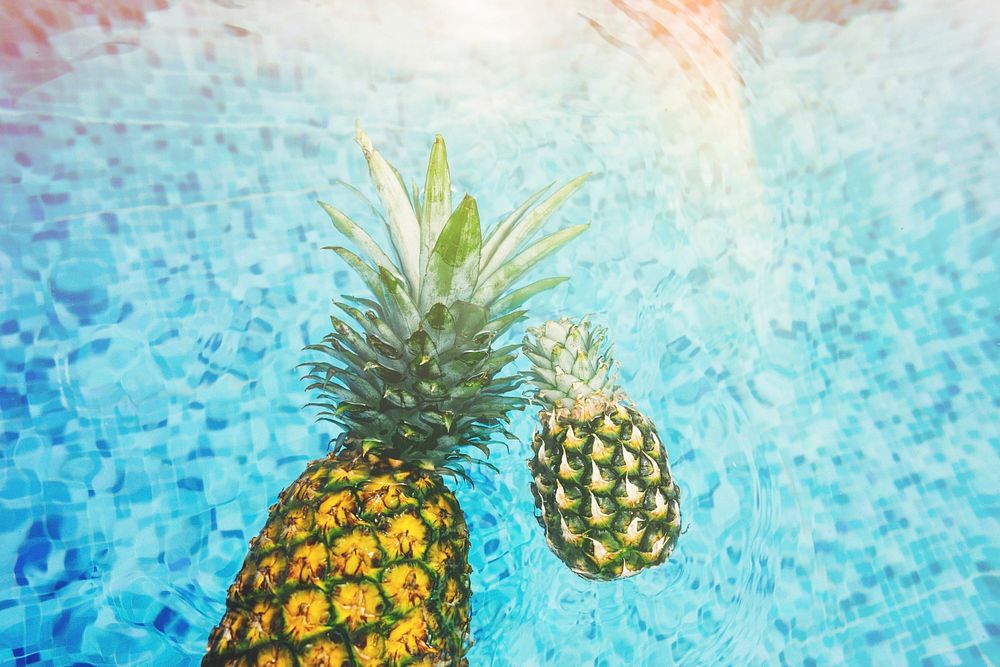 Pineapples floating in swimming pool. Original public domain image from Wikimedia Commons