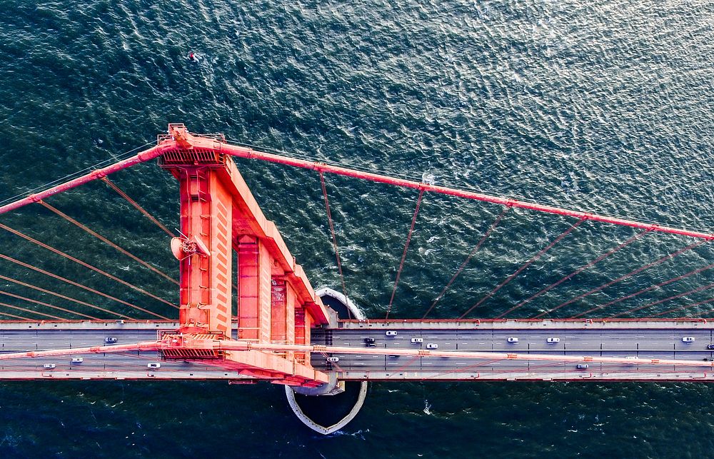 Drone view of cars driving along San Francisco Golden Gate Bridge and water. Original public domain image from Wikimedia…