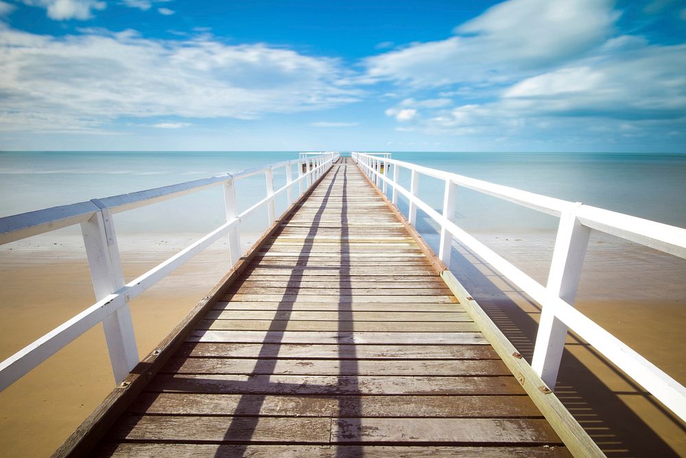 Wooden pier pathway with white wooden railing. Original public domain image from Wikimedia Commons
