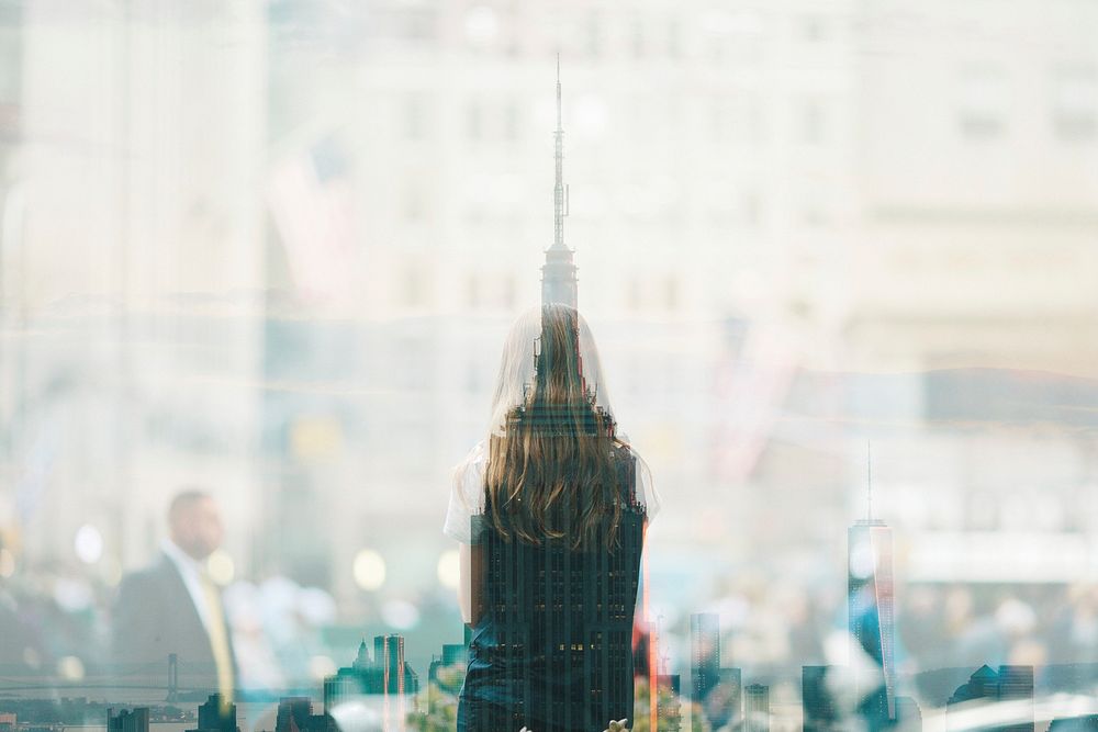 A reflection of a skyscraper and a woman's back in a storefront. Original public domain image from Wikimedia Commons