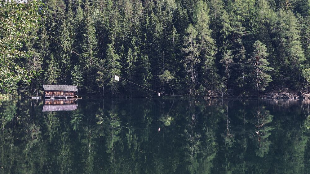 A cabin on a quiet lake on a sunny day. Original public domain image from Wikimedia Commons