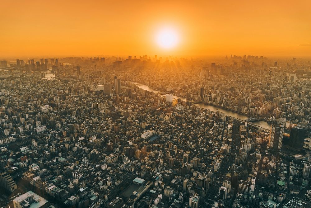 An orange sunset covers the buildings and skyscrapers of Tokyo, Japan — turning the skies into a bright orange. Original…