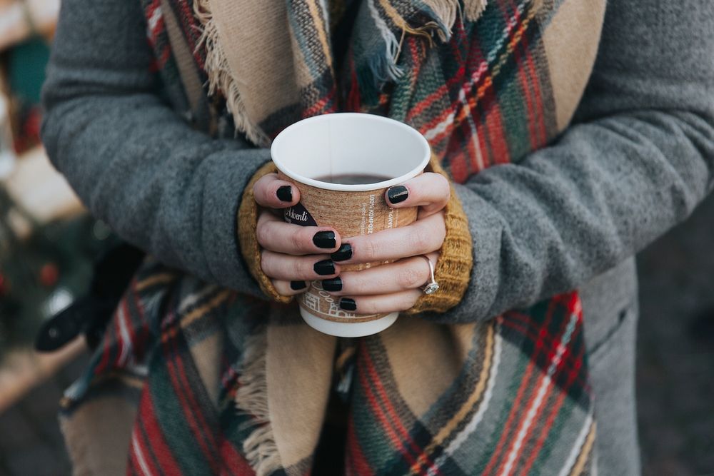 Girl holding a warm cup of coffee. Original public domain image from Wikimedia Commons