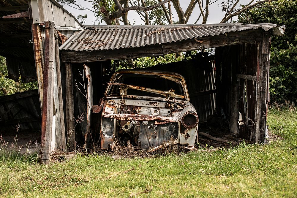 A broken down old car in an abandoned shed in Newcastle. Original public domain image from Wikimedia Commons