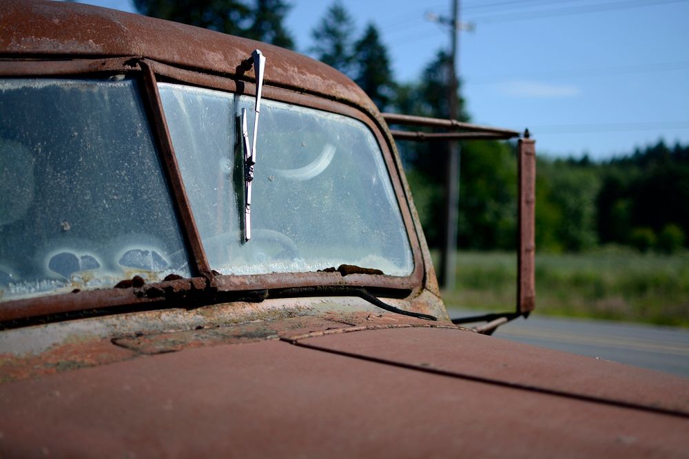 Windshield and broken window wiper of a rusty, burgundy truck in Sherwood during daylight. Original public domain image from…