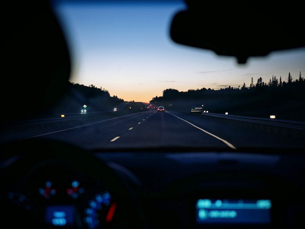 View through a windshield on the road at dusk. Original public domain image from Wikimedia Commons