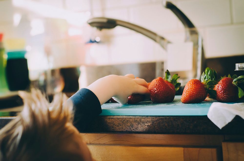 Kid reaching for a strawberry. Original public domain image from Wikimedia Commons