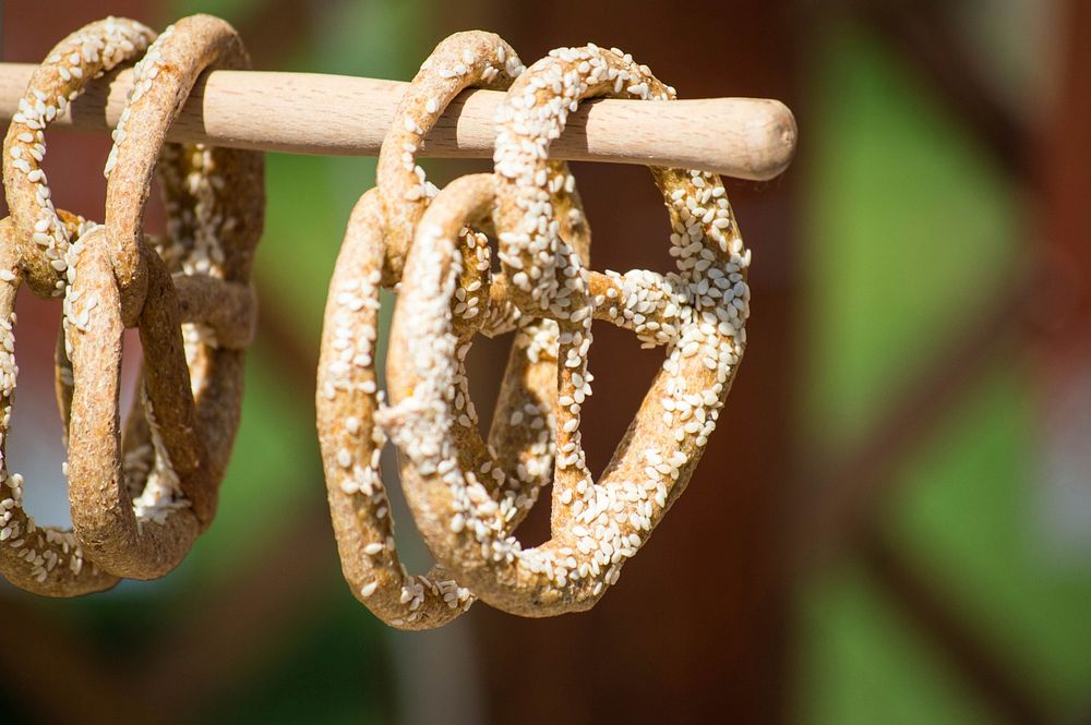 Four pretzels covered in sesame seeds on a wooden pole in Novi Sad. Original public domain image from Wikimedia Commons