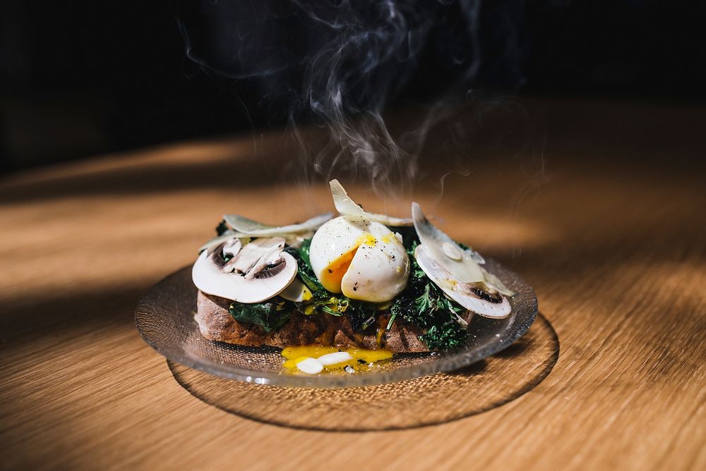 Gourmet cafe toast with a steaming poached egg, mushrooms, and greens. Original public domain image from Wikimedia Commons