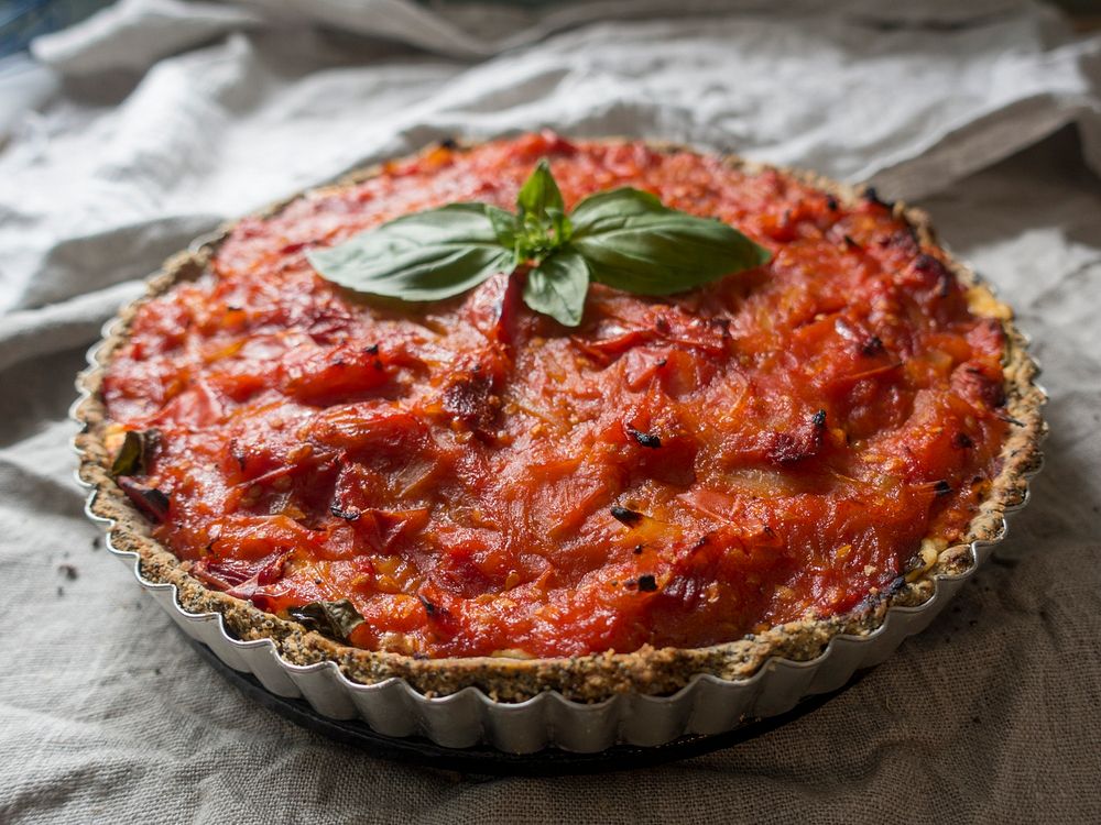 A tart with tomato sauce and basil on top. Original public domain image from Wikimedia Commons