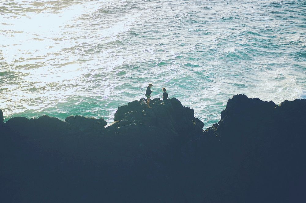 Two people stood on the rocks at the most easterly point of the Australian mainland, with the sea beneath them. Original…