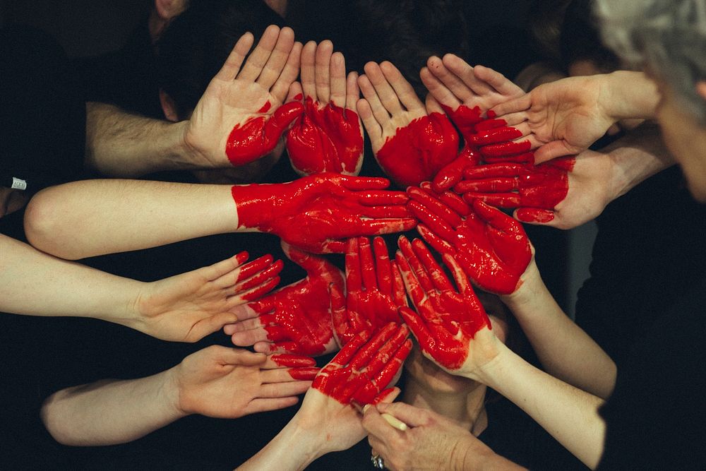 Many people's hands are painted red to form together a large red heart. Original public domain image from Wikimedia Commons