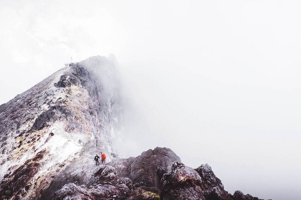 Hikers walk toward the summit of snowy mountain in fog. Original public domain image from Wikimedia Commons