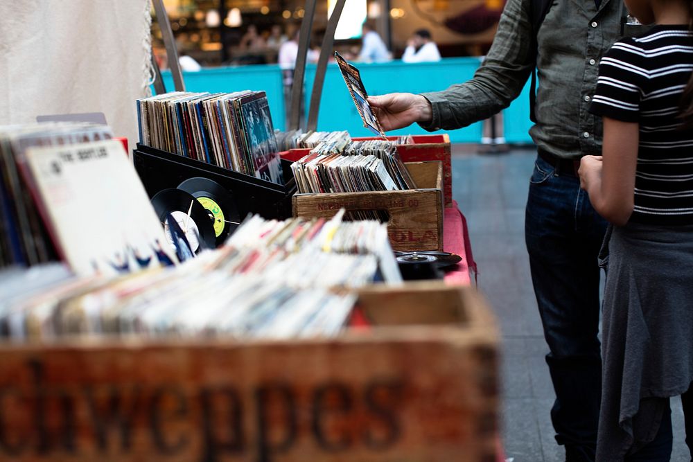 A man and a child browsing vinyl records from vintage boxes. Original public domain image from Wikimedia Commons