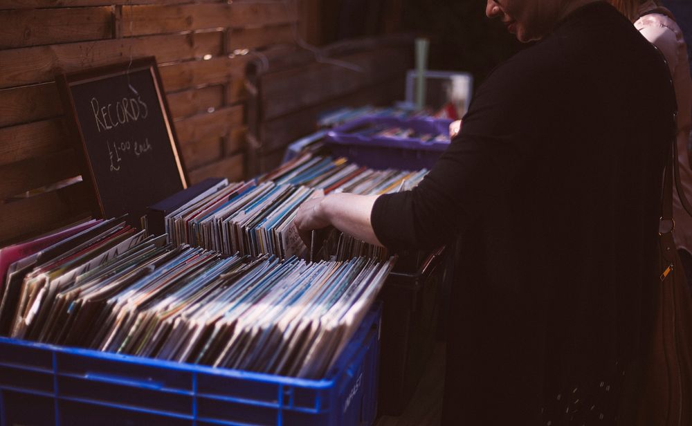 A person browsing a collection of vinyl records for sale in Brighton. Original public domain image from Wikimedia Commons