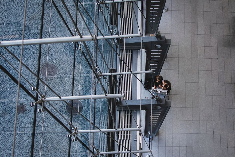 An overhead shot of two people working at laptops in the Royal Library. Original public domain image from Wikimedia Commons