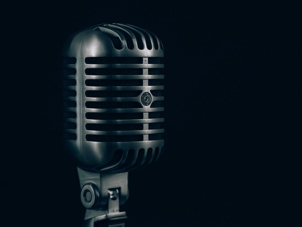 Close-up of a condenser microphone in a steel casing against a black background. Original public domain image from Wikimedia…