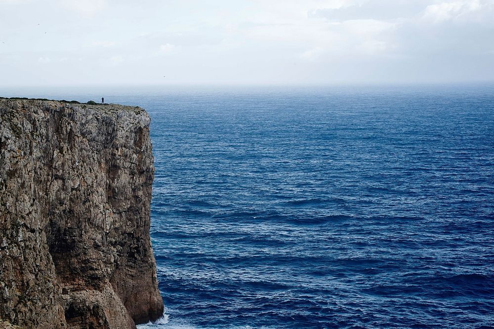 A rocky cliff overlooking a brilliant blue sea at Sagres. Original public domain image from Wikimedia Commons