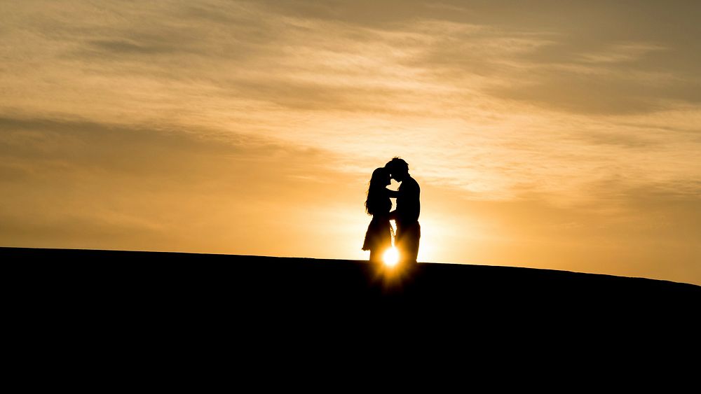 Man and woman's silhouette on hill during golden hour. Original public domain image from Wikimedia Commons