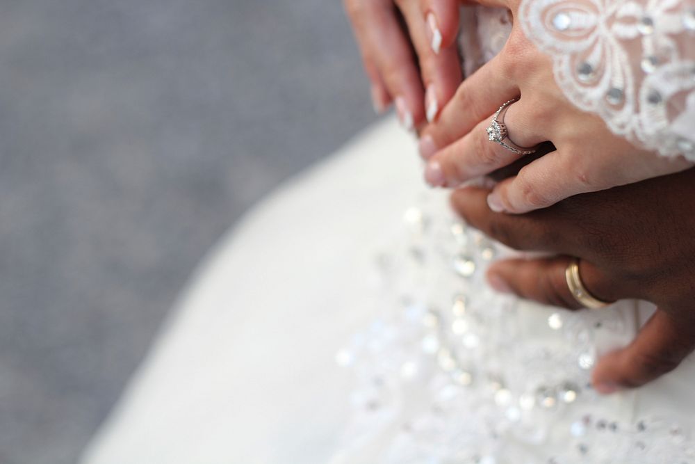 Couple's hands touch gingerly on their wedding day. Original public domain image from Wikimedia Commons
