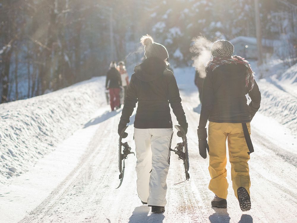 A few snowboarders walking a winter path with visible breath. Original public domain image from Wikimedia Commons